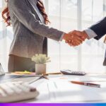 Parceria corporativa representada por aperto de mãos em ambiente de negócios com relatórios de crescimento e tecnologia.