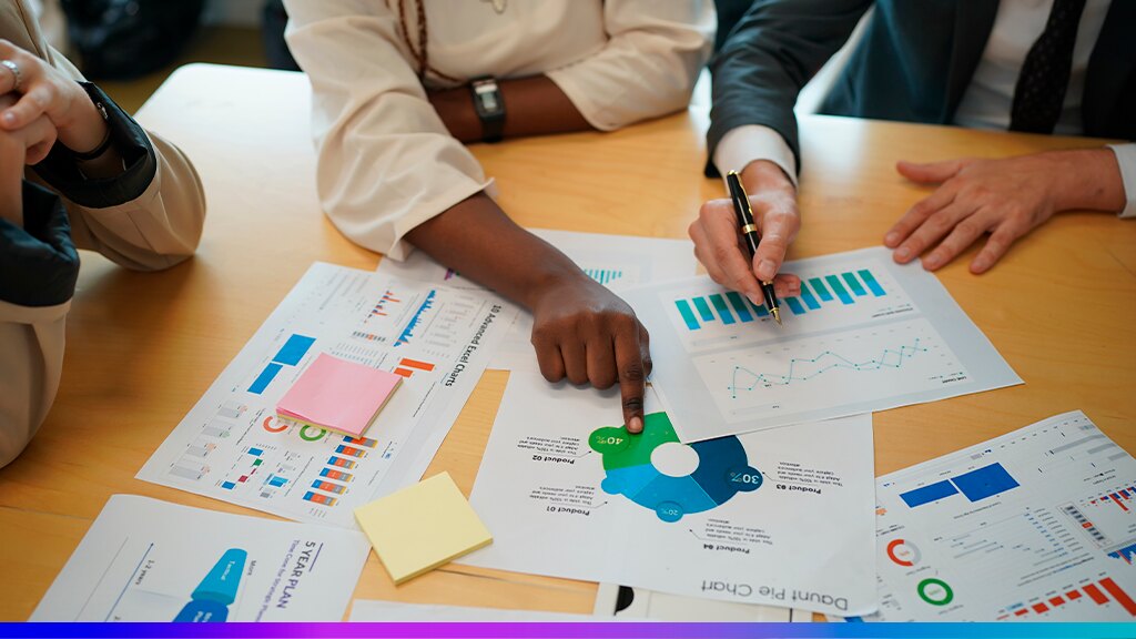 Profissionais analisando relatórios e gráficos coloridos em uma reunião de negócios, simbolizando a aplicação de Data Visualization para apoiar decisões de alto nível.
