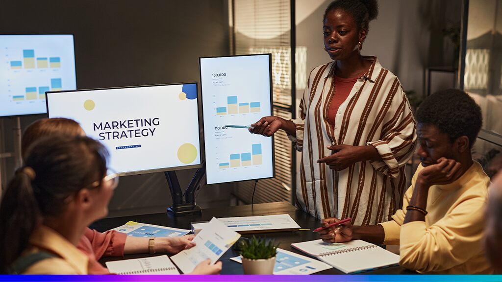 Equipe de marketing analisando dados e gráficos durante uma reunião estratégica sobre o uso de First-Party Data em campanhas de mídia paga.